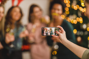 Multiracial Group Of Female Friends Making Memories Photos With Smartphone During Celebrating Christmas