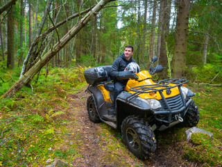 Man on a quad bike. ATV driver in the forest. A portrait of an quad bike driver. Concept - riding...
