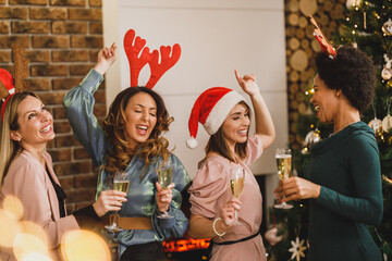 Four Multi Ethnic Female Friends Having Fun And Dancing At Home Christmas Party