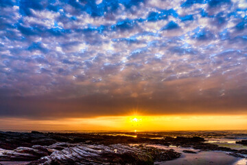 Obraz premium Sunset over the Ocean, clouds, waves, beach
