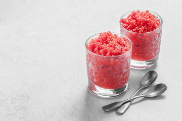 Sicilian strawberry granita. Traditional Italian summer dessert in glass on light grey stone background with copy space. Ingredients: strawberries, water, sugar, or powdered sugar. It without alcohol.
