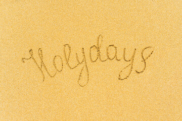 Painted holydays word on the beach sand. concept