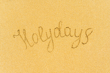 Painted holydays word on the beach sand. concept