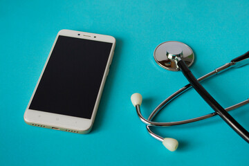 Medical concept: stethoscope and mobile phone on a bright blue background. House call. Ambulance. With copy space.
