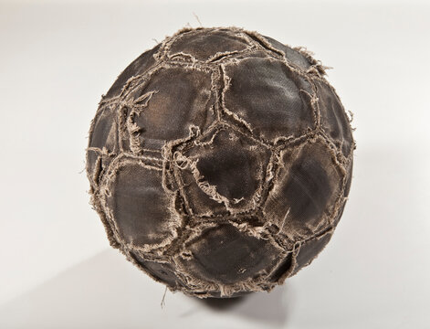 Bola de futebol desgastada por uso intenso no fundo branco para recorte.