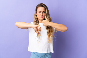Fototapeta premium Young Brazilian woman isolated on purple background making good-bad sign. Undecided between yes or not