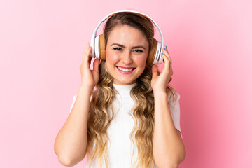 Fototapeta premium Young brazilian woman isolated on pink background listening music