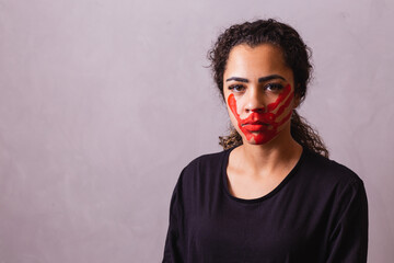 Afro woman with handprint on her mouth in favor of awareness of feminicide. Domestic violence