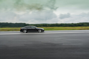 Fototapeta premium Side view of a high performance luxury car in motion 