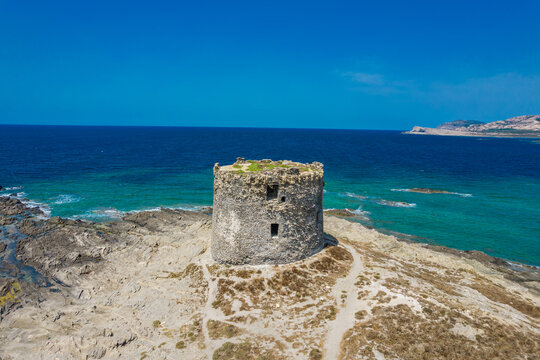 Aerial view of nuraghe in a island in Stintino, La Pelosa beach in Mediterranean sea. The nuraghe or also nurhag in English, is the main type of ancient megalithic edifice found in Sardinia.