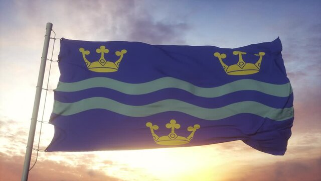 Cambridgeshire flag, England, waving in the wind, sky and sun background