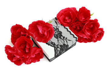 Red garden roses (flower head) on a white gift box, decorated with exquisite black lace ribbon, isolated on white