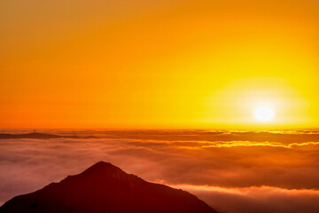 Silhouetted Mountain Peak at sunset, cloud layer