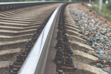 Railway rails and sleepers close-up. A railway that goes around a bend in the distance.