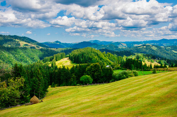 Fototapeta na wymiar pastures of young green grass on the slopes of the mountains against the backdrop of a beautiful blue sky. High quality photo