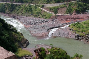 River current flowing in the valley around the smooth rocks