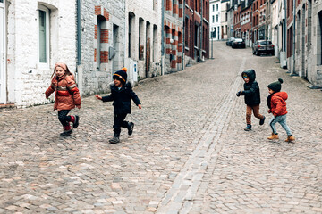 group of multiethnic children playing on the street in winter