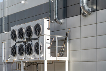 Outdoor split air conditioner units mounted on industrial building facade. Outdoor blocks of split...