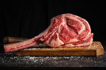 Fresh tomahawk steak on old board - 457203151