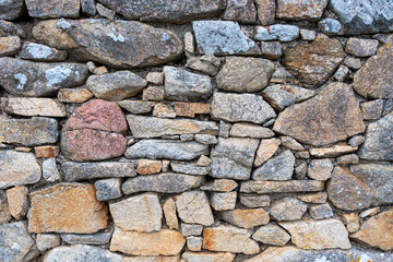 Détail d'un mur de pierres irrégulières et colorées