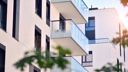 Ecological housing architecture. A modern residential building in the vicinity of trees. Ecology and green living in city, urban environment concept. Modern apartment building and green trees.