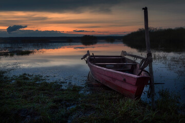 Fototapeta na wymiar A moored boat at sunset lake, Russian North-West