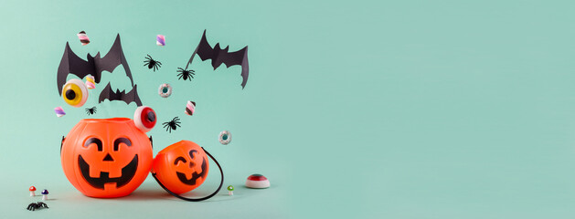 Happy Halloween day banner with cute pumpkins, flying paper cut bats, sweets and spiders against light blue with empty space for text.