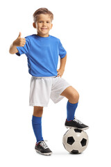 Cute little boy in a sports jersey stepping on a soccer ball and gesturing thumbs up © Ljupco Smokovski