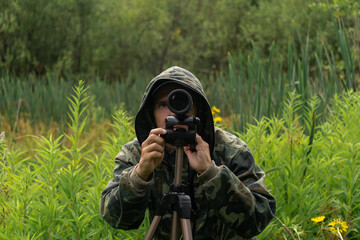man wildlife researcher makes observations in the wild with a spotting scope
