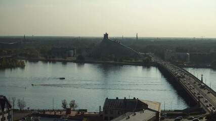 The Riga town infrastructure aerial view to the Daugava river opposite side in Latvian capital with a view of city transport traffic over the bridge, and the building of the National Library of Latvia