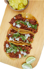 Tacos al pastor, tradicional comida mexicana, con cebolla, cilantro, pi&ntilde;a, salsa roja o guacamole.
