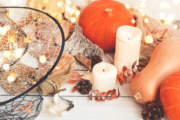 Halloween or Thanksgiving day. Ripe orange pumpkins next to bright garlands, autumn leaves. Magic...