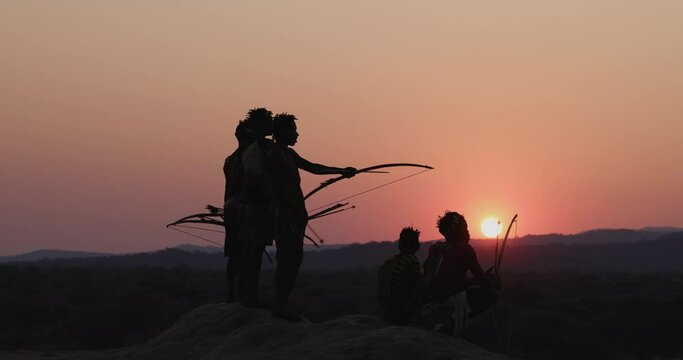Group of Hadza hunter-gatherer tribesmen out hunting at sunset Tanzania