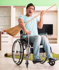 Disabled man on wheelchair cleaning house