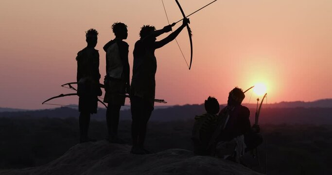 Group of Hadza hunter-gatherer tribesmen out hunting at sunset Tanzania