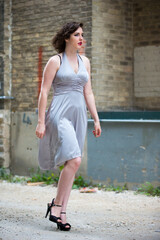 A young female model poses in an alley. 