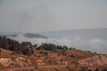 Beautiful mountains landscape,  fluffy clouds descended to the mountain tops. Nature mountain wallpaper.