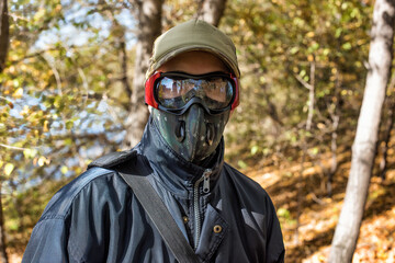 A man wearing respirator mask and protective glasses walking in the forest at COVID-19 period.