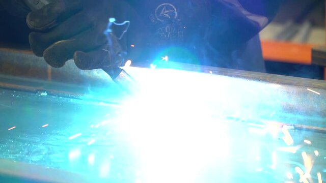 Bright light and lots of sparks while a professional worker is welding