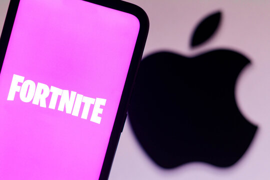 September 13, 2021, Brazil. In this photo illustration the Fortnite logo seen displayed on a smartphone with a Apple logo in the background.