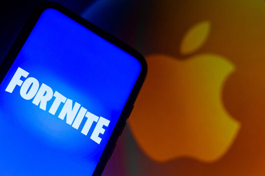 September 13, 2021, Brazil. In this photo illustration the Fortnite logo seen displayed on a smartphone with a Apple logo in the background.