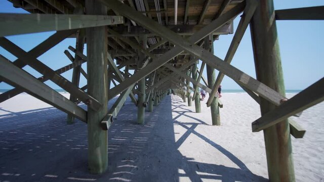Walking under pier on the beach