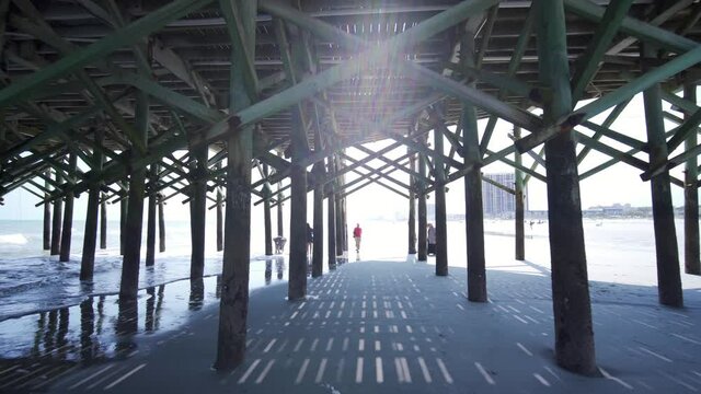 Boardwalk at the beach. People walking on the beach.