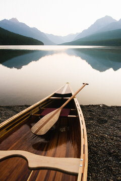Wood canoe on the edge of Bowman Lake at sunrise in Glacier National Park, Montana