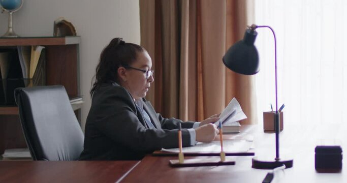 Mujer de negocios de la tercera edad revisando documentos en su oficina.