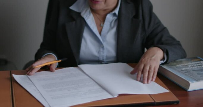 Mujer de negocios de la tercera edad revisando documentos en su oficina.