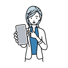 立ってスマートフォンを指差してこちらに向けて見せているジャケットの女性