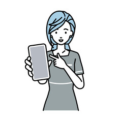 立ってスマートフォンを指差してこちらに向けて見せているエステ店員の女性