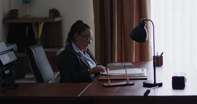 Mujer de negocios de la tercera edad revisando documentos en su oficina.