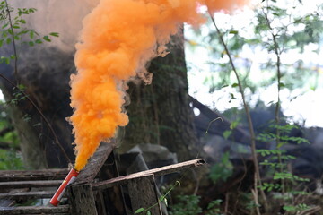 Smoke bombs with orange smoke in the forest